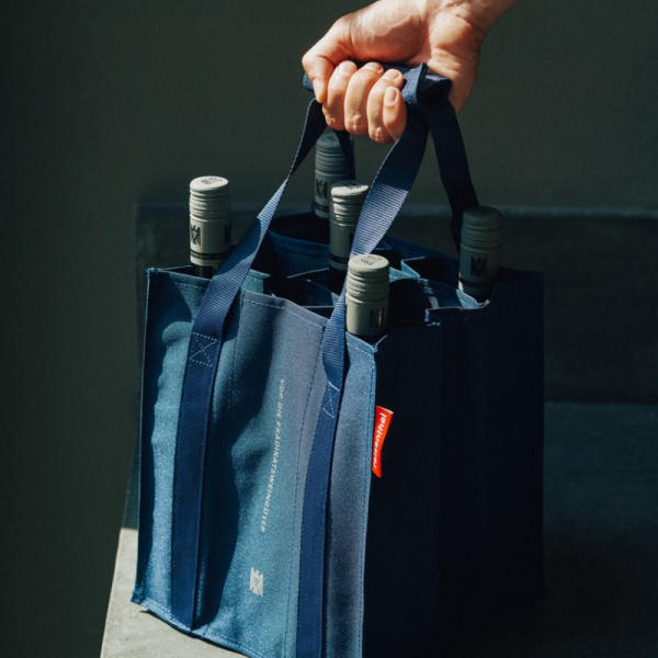 A bottle bag filled with wine bottles is carried with one...