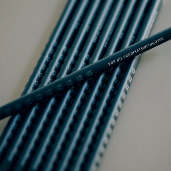 Black pencils are lying side by side. A pencil is lying...