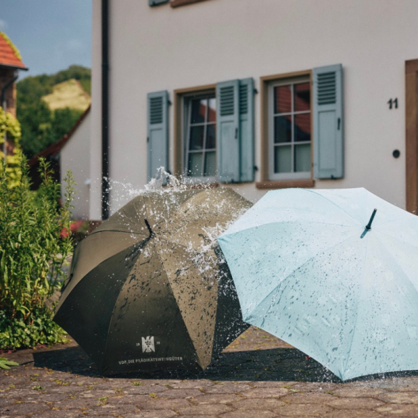 Two umbrellas are open on the floor, and water is running...